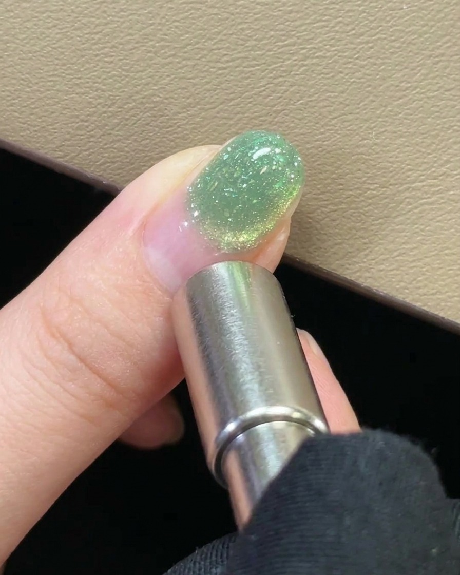 A close-up of the finished magnetic gel design on the nail before curing.