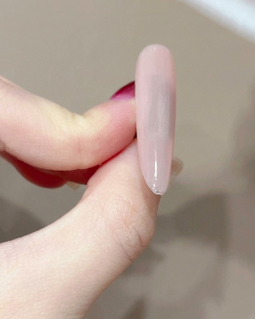 A lint-free wipe cleaning the surface of a cured gel nail.