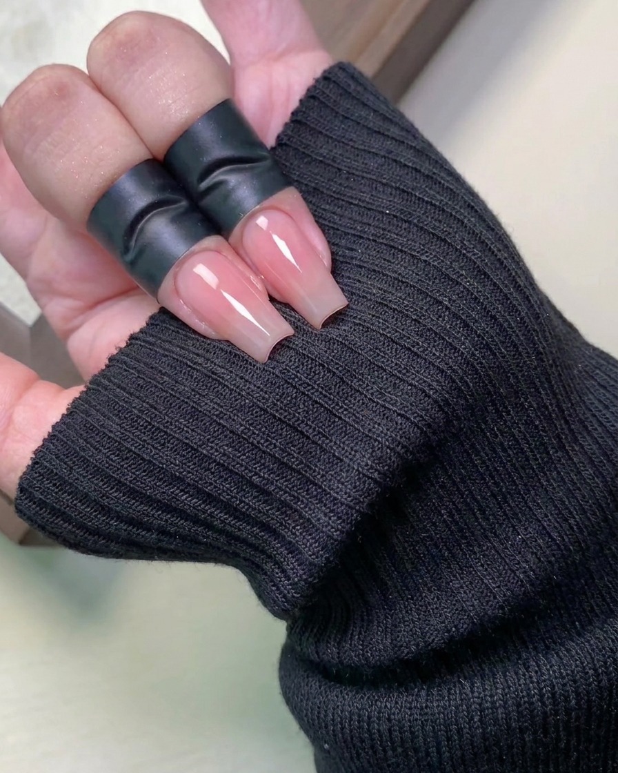 A sponge applicator dabbing fine, iridescent moonlight powder onto the tip of a nail to create a gradient.