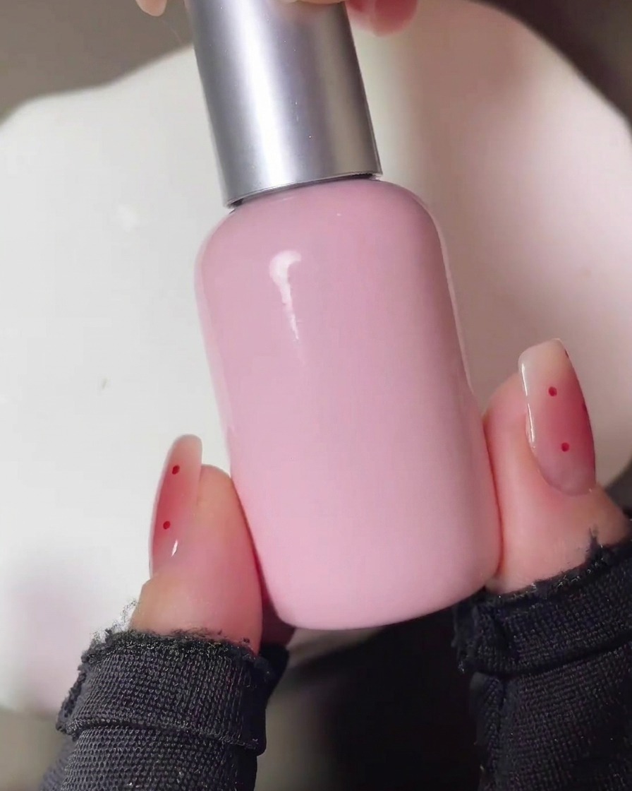 The nails being cured under a UV lamp after the initial application of the red blush pigment.