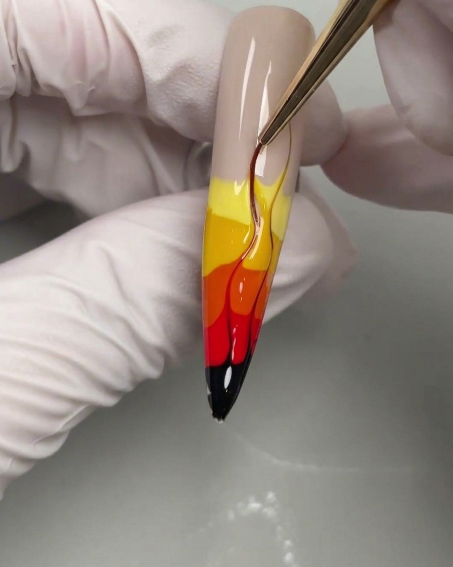 A liner brush refining the flame shapes into thin pointed tips.
