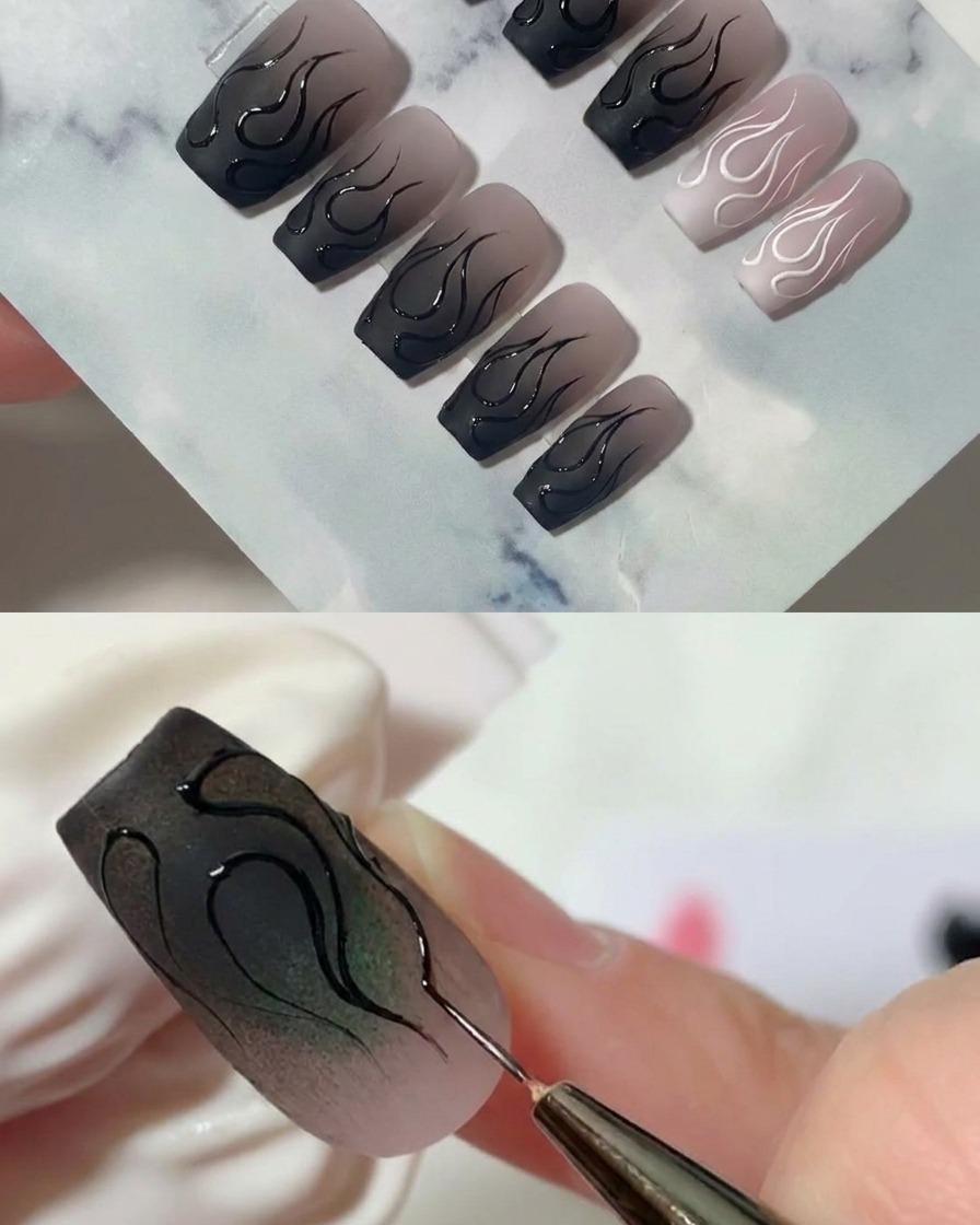 A close-up shot of a liner brush carefully dragging out a sharp tip on the edge of a flame design.