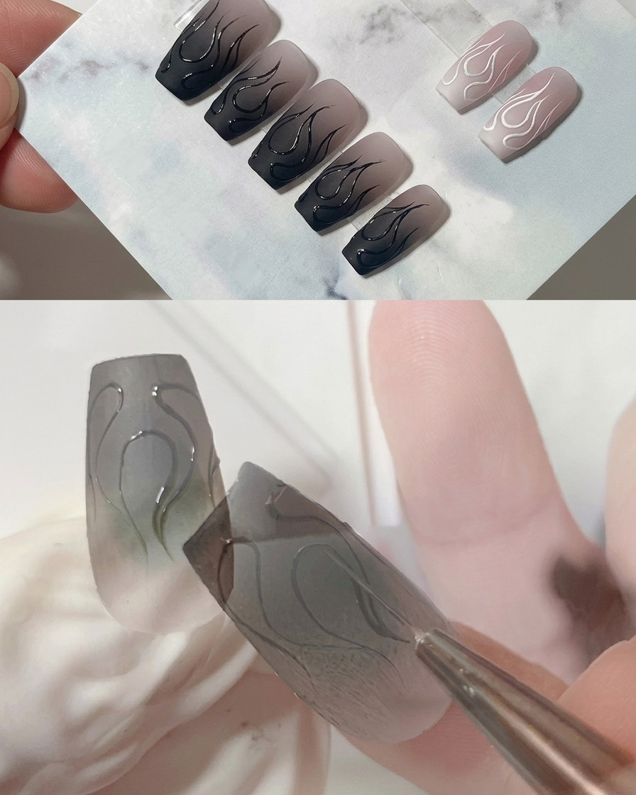 A macro shot of a liner brush refining the sharp point of the central flame on a matte grey nail.