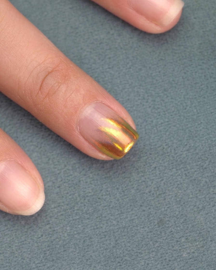 A hand positioned inside a UV/LED nail lamp, with nails currently curing.