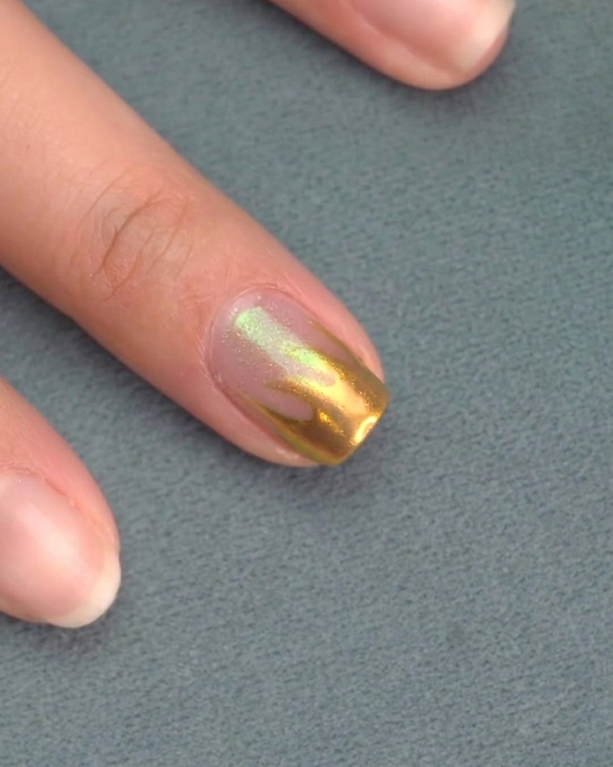 Applying a clear matte top coat over the pink-painted nails.