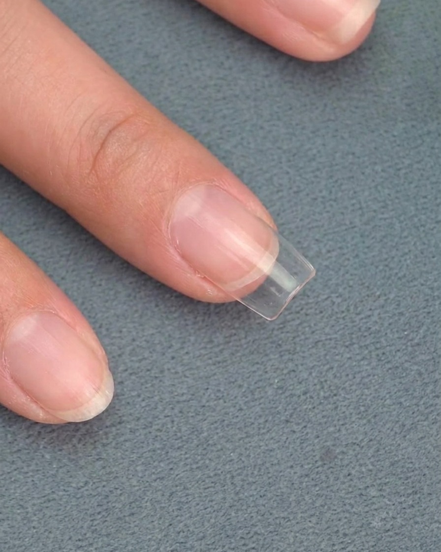 A sponge applicator dabbing gold chrome powder onto the flame-shaped nail art.