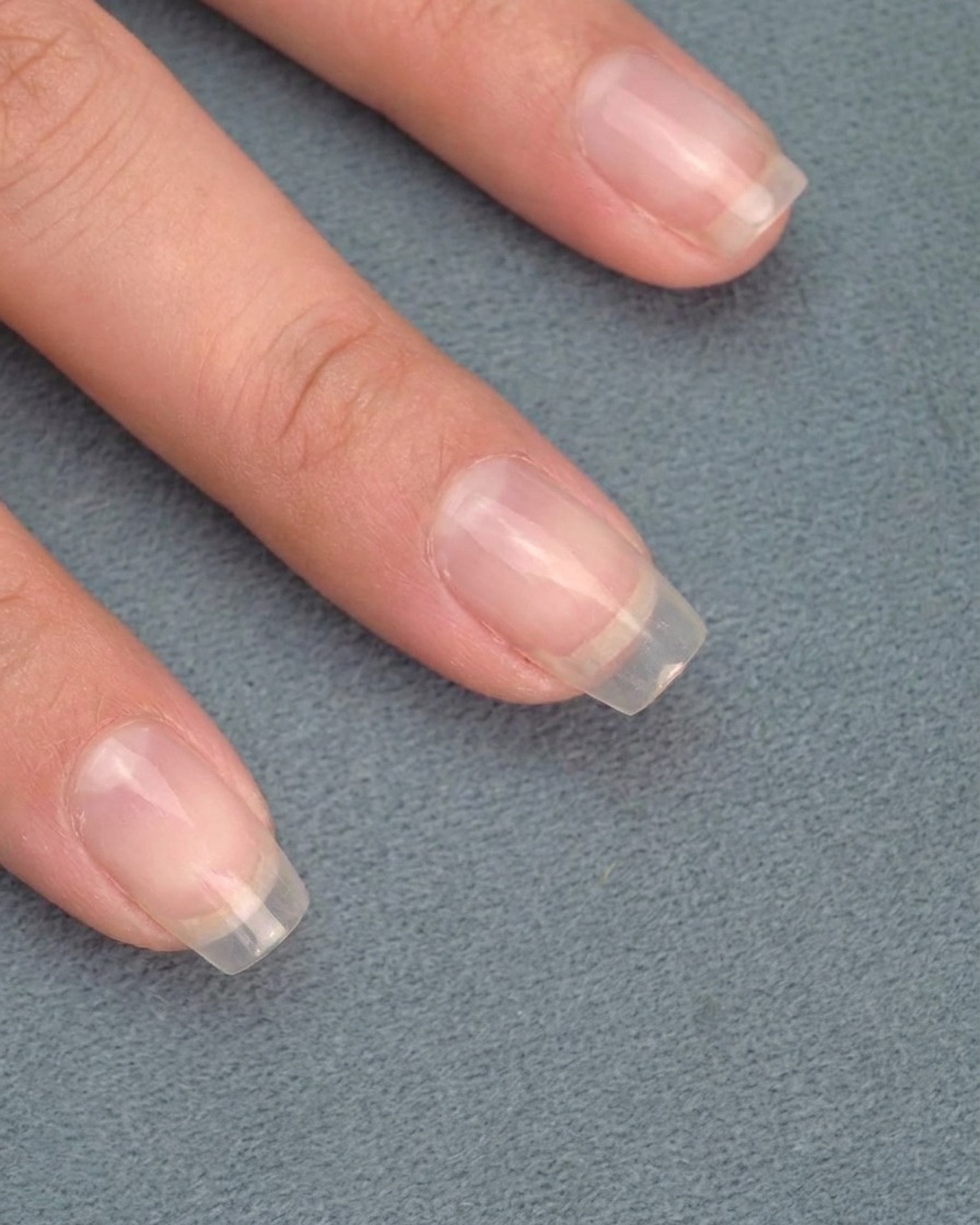Close-up of a tool buffing chrome powder to reveal a metallic, mirror-like finish on the nails.
