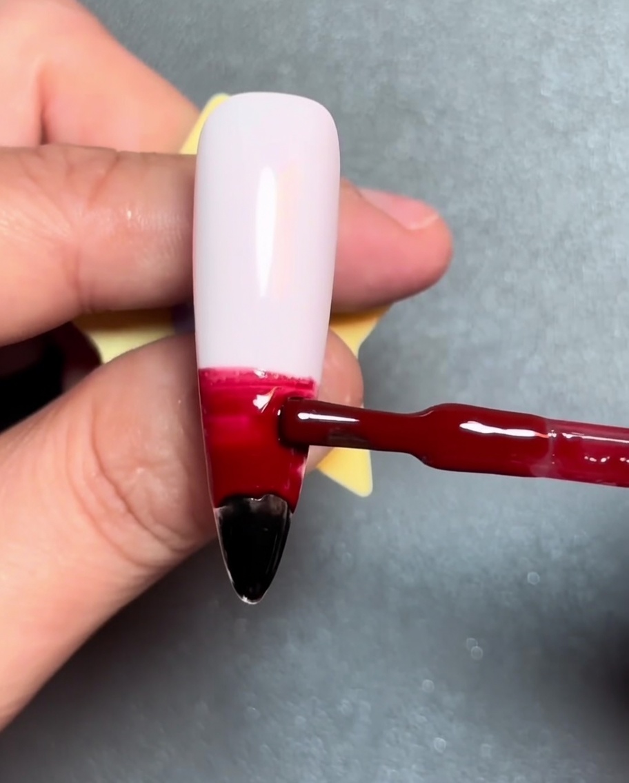 A brush applying a horizontal orange gel stripe above the red gel.