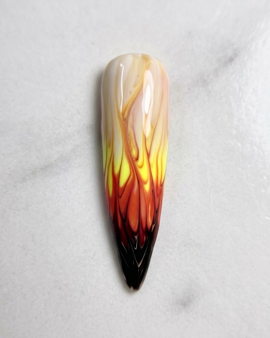 A top-down view of the completed flame nail art design, perfectly blended and ready for the curing process.