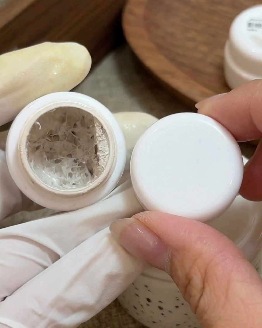 A small brush applying white painting gel to the base of a prepped natural nail.