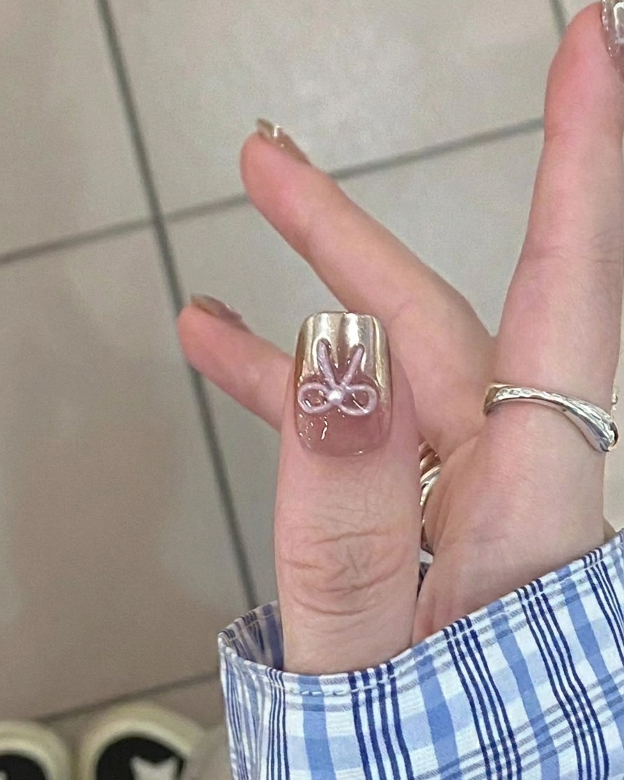 A close-up view of a brush applying a sheer nude gel base coat onto a clean natural fingernail.