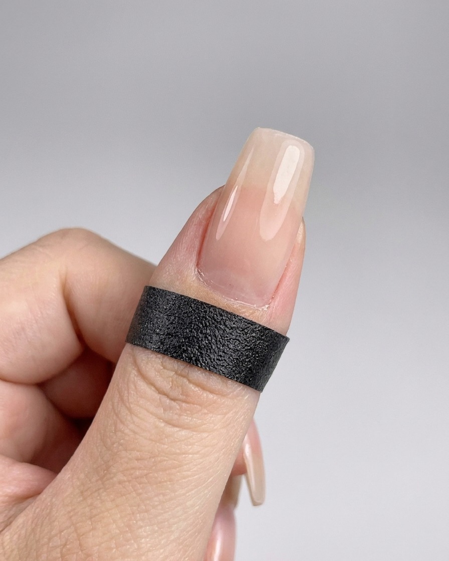 A hand positioned inside a UV nail lamp to cure the freshly applied top coat.