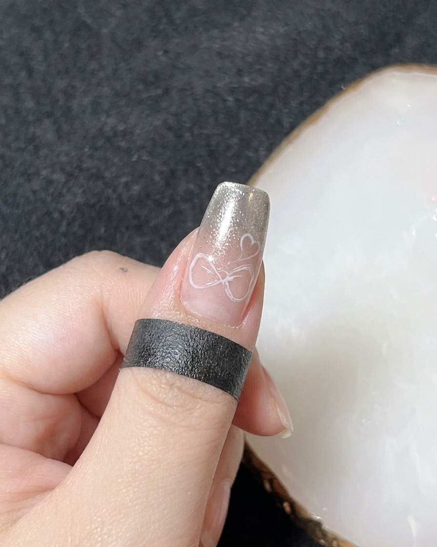 A hand placed inside a professional UV nail lamp for the curing process of the 3D gel art.