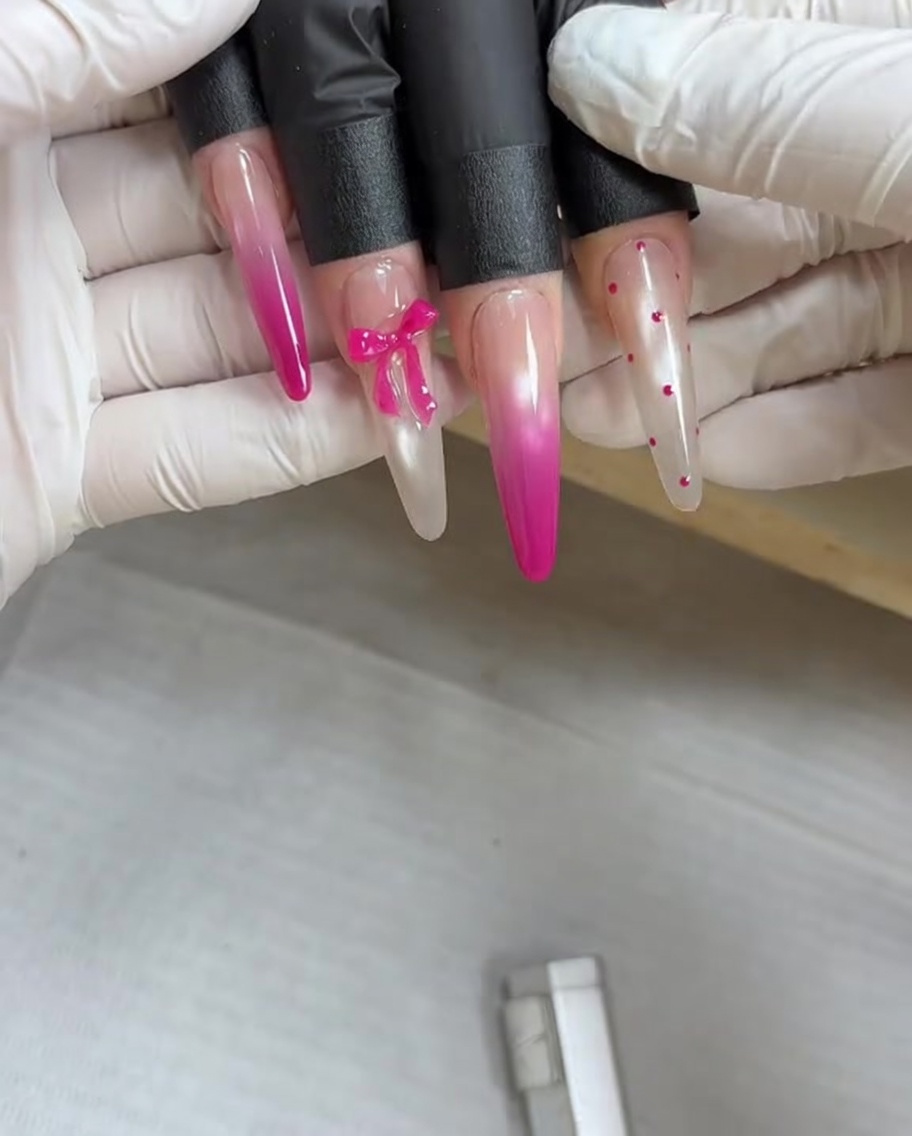 A magnetic tool held above a fingernail coated in wet metallic gel to pull the magnetic pigments into a design.
