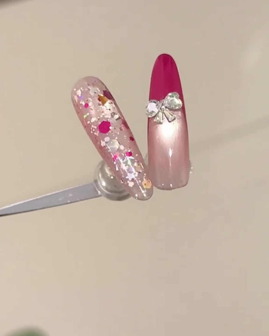 A close-up of a hand with a rose red French manicure being placed inside a UV nail lamp.