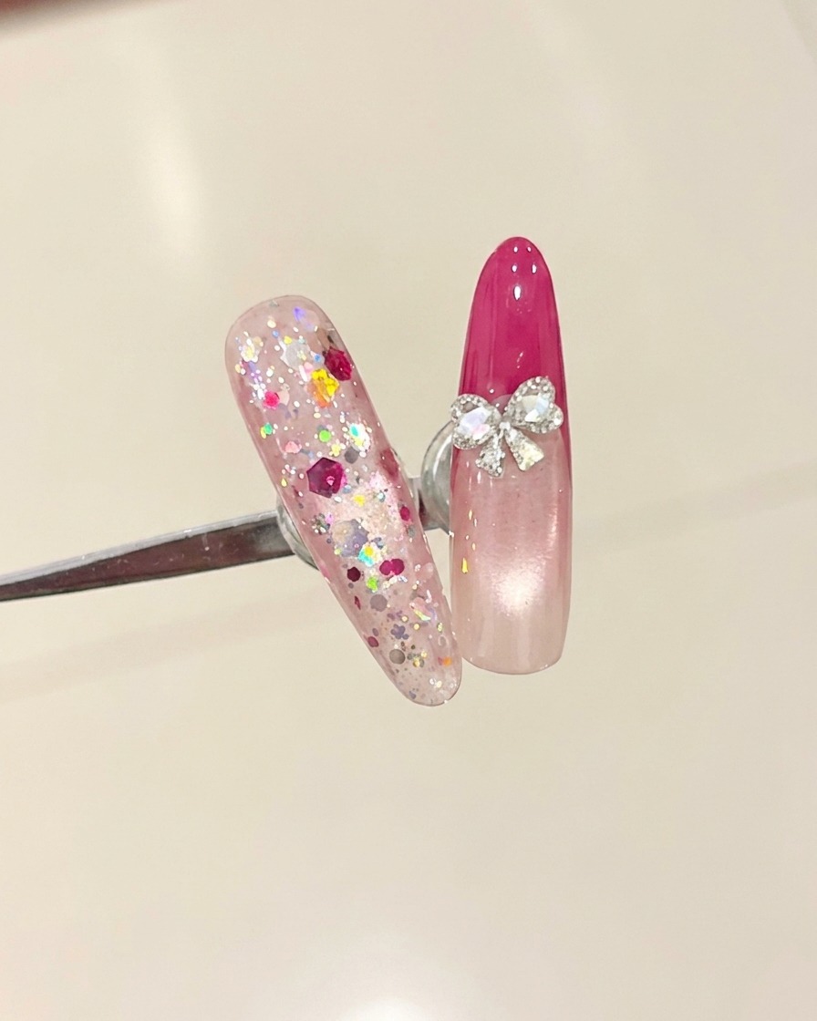 A brush applying a clear top coat over a nail with a rose red French tip.