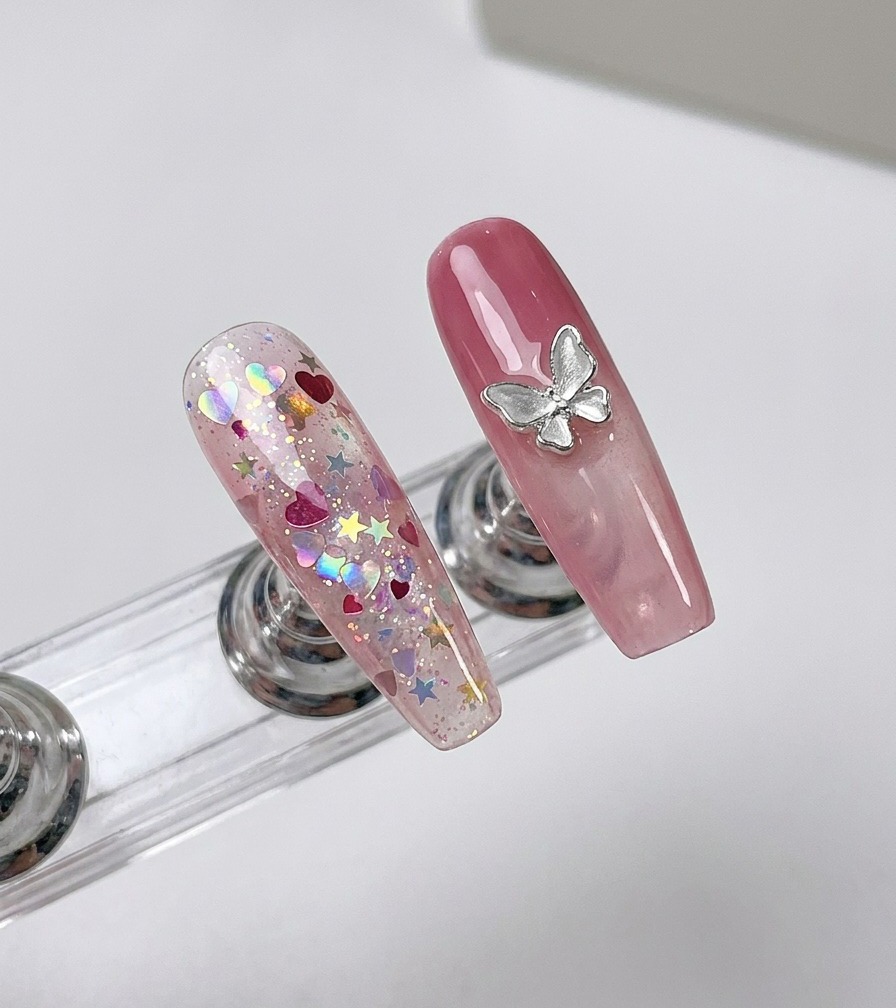 A close-up of a finger with a glitter-covered nail being positioned under a nail curing lamp.