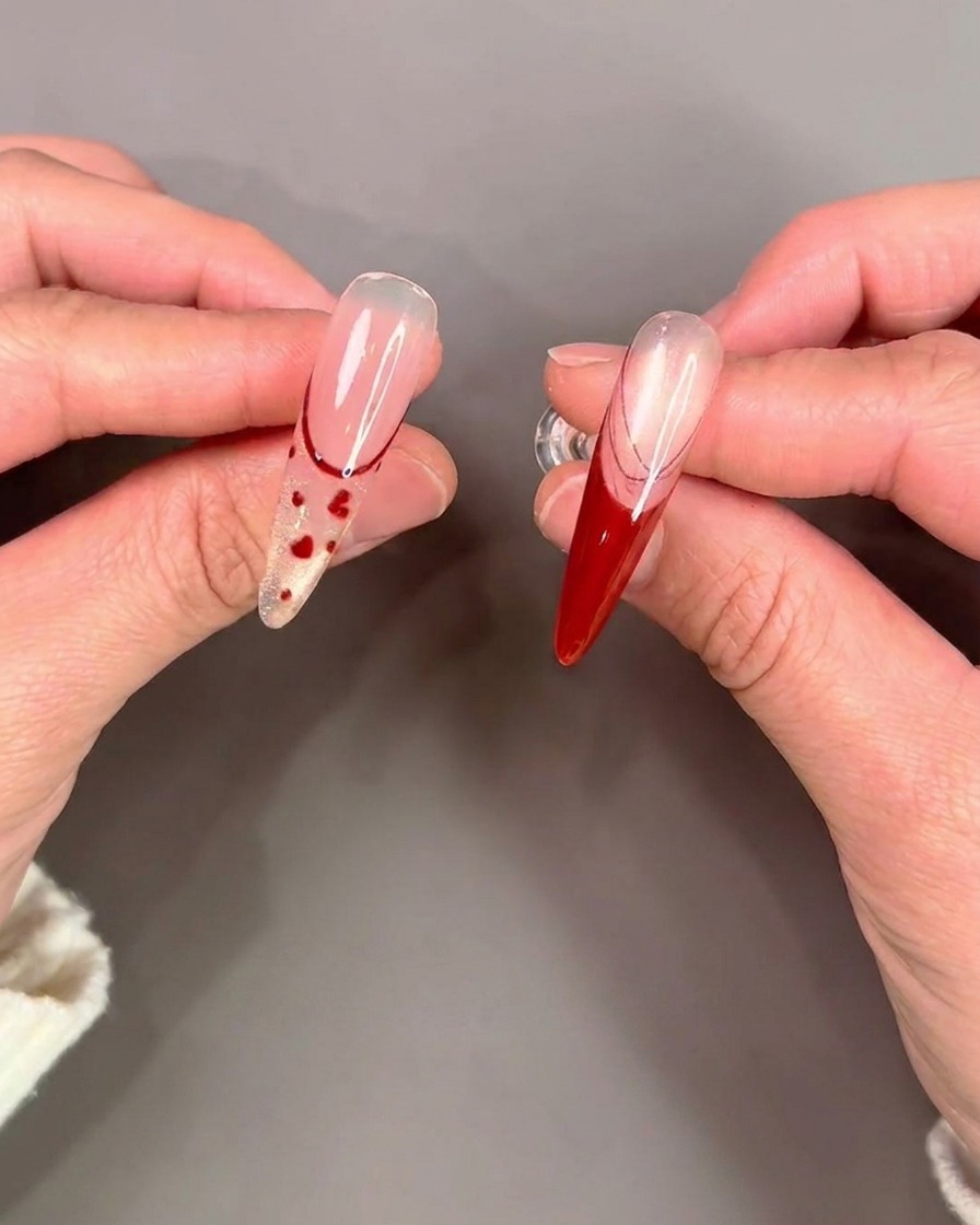 A brush applying a clear, glossy top coat over a completed nail design.
