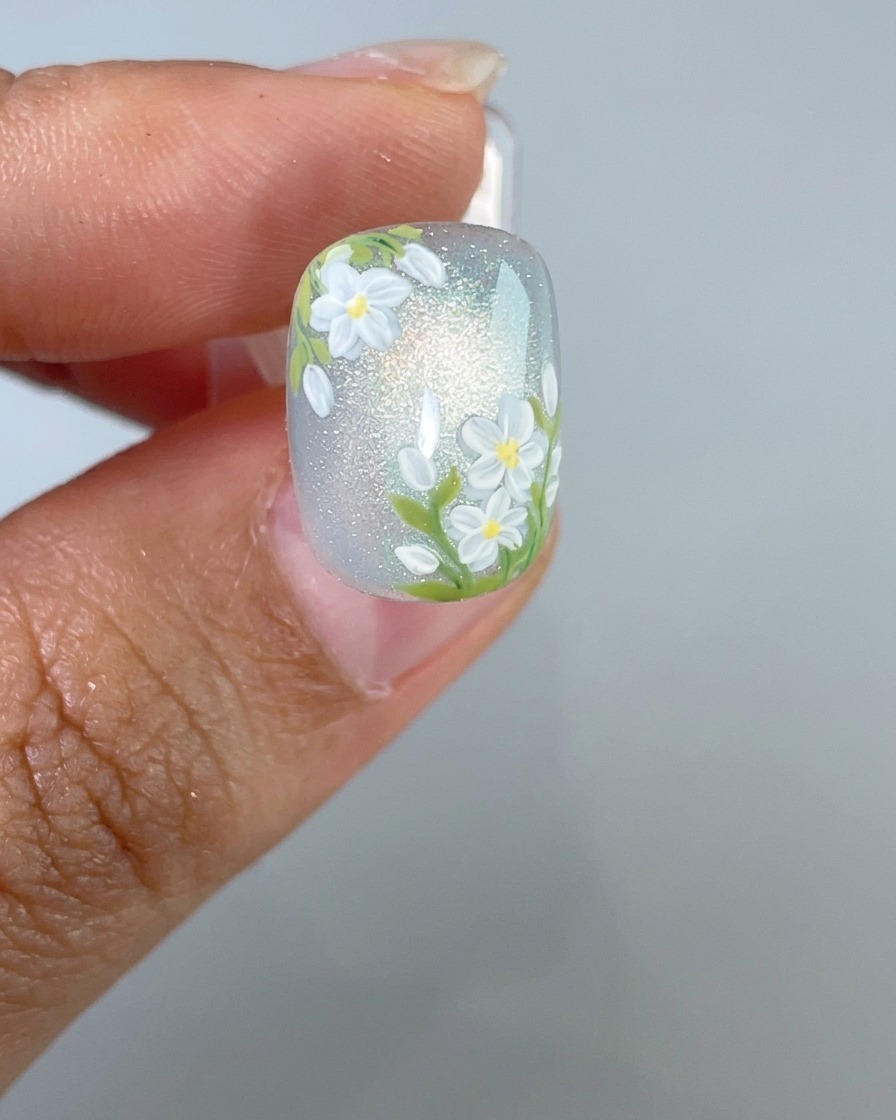 A finished nail being placed under a UV nail lamp for the final curing process.