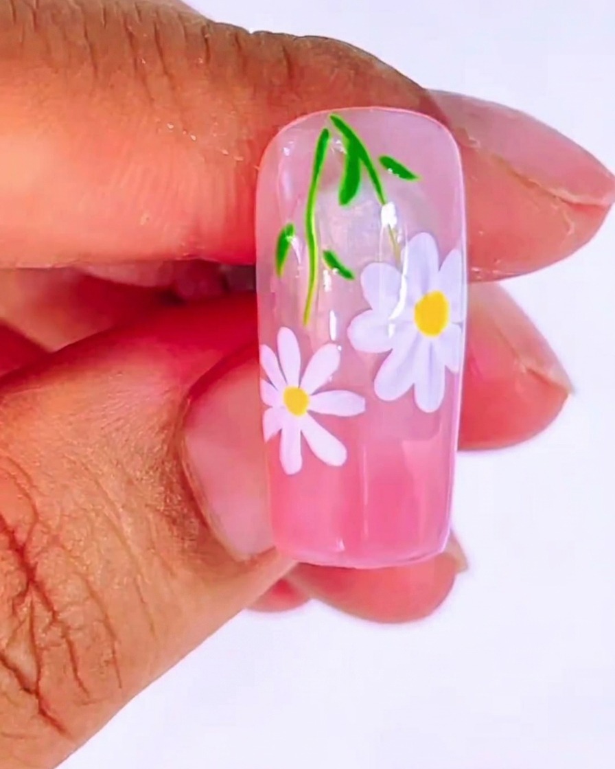 A nail tip with a smooth pink gradient base coat applied.