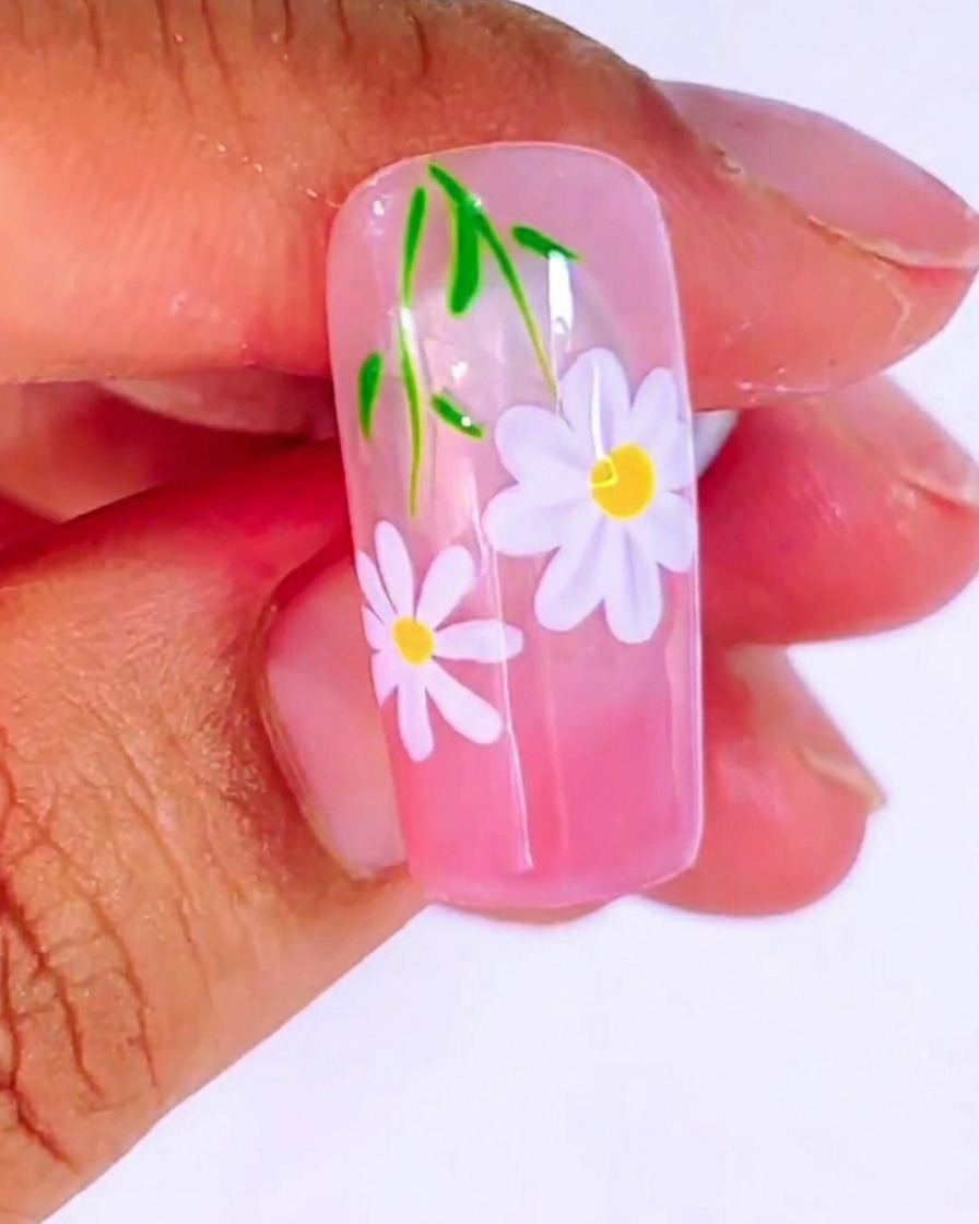 A close-up of a liner brush painting a delicate white 米 shape on the nail surface.