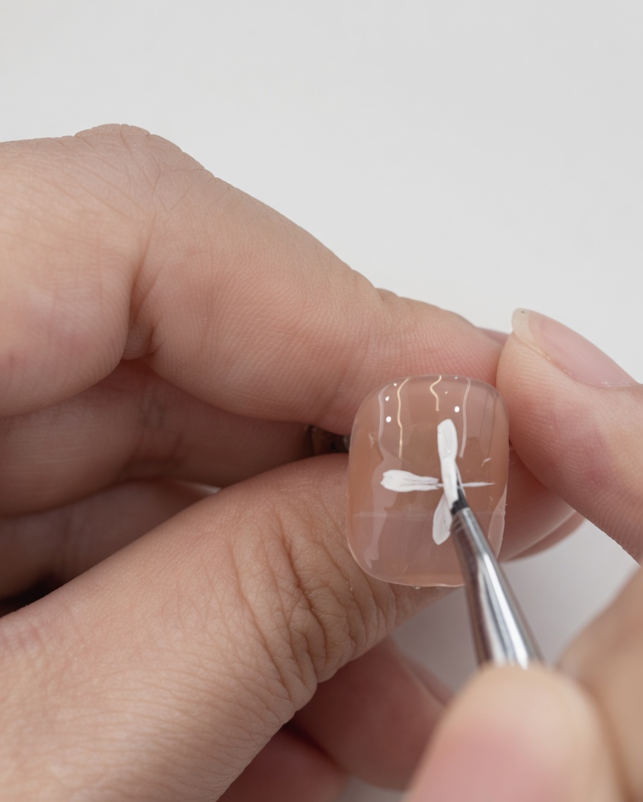 Four white petals painted on the nail, creating a complete cross or plus-sign shape.