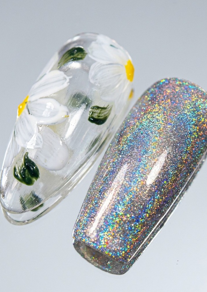 A nail tip with daisy art receiving a thin, vibrant yellow border application along the nails edge.