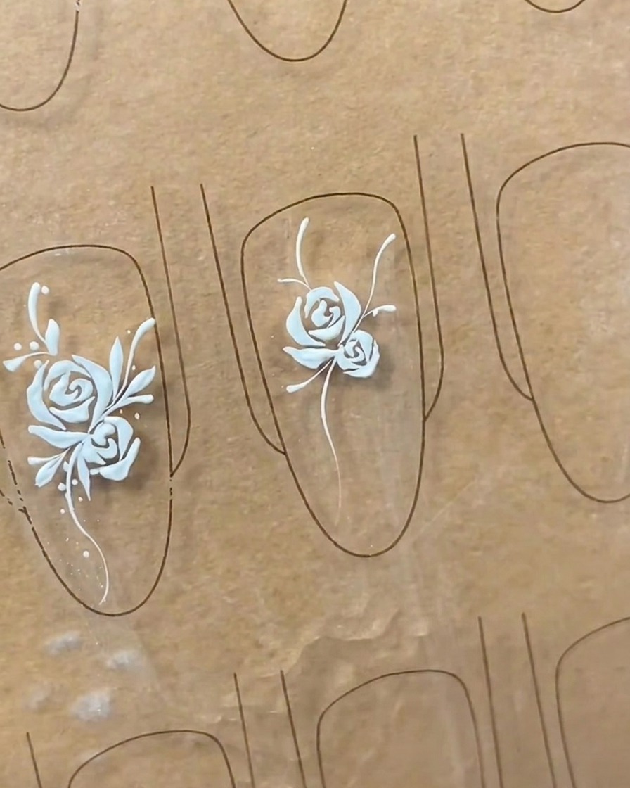 Close-up showing the refinement of leaf shapes on a nail art design, adding detail and fullness to the leaves.