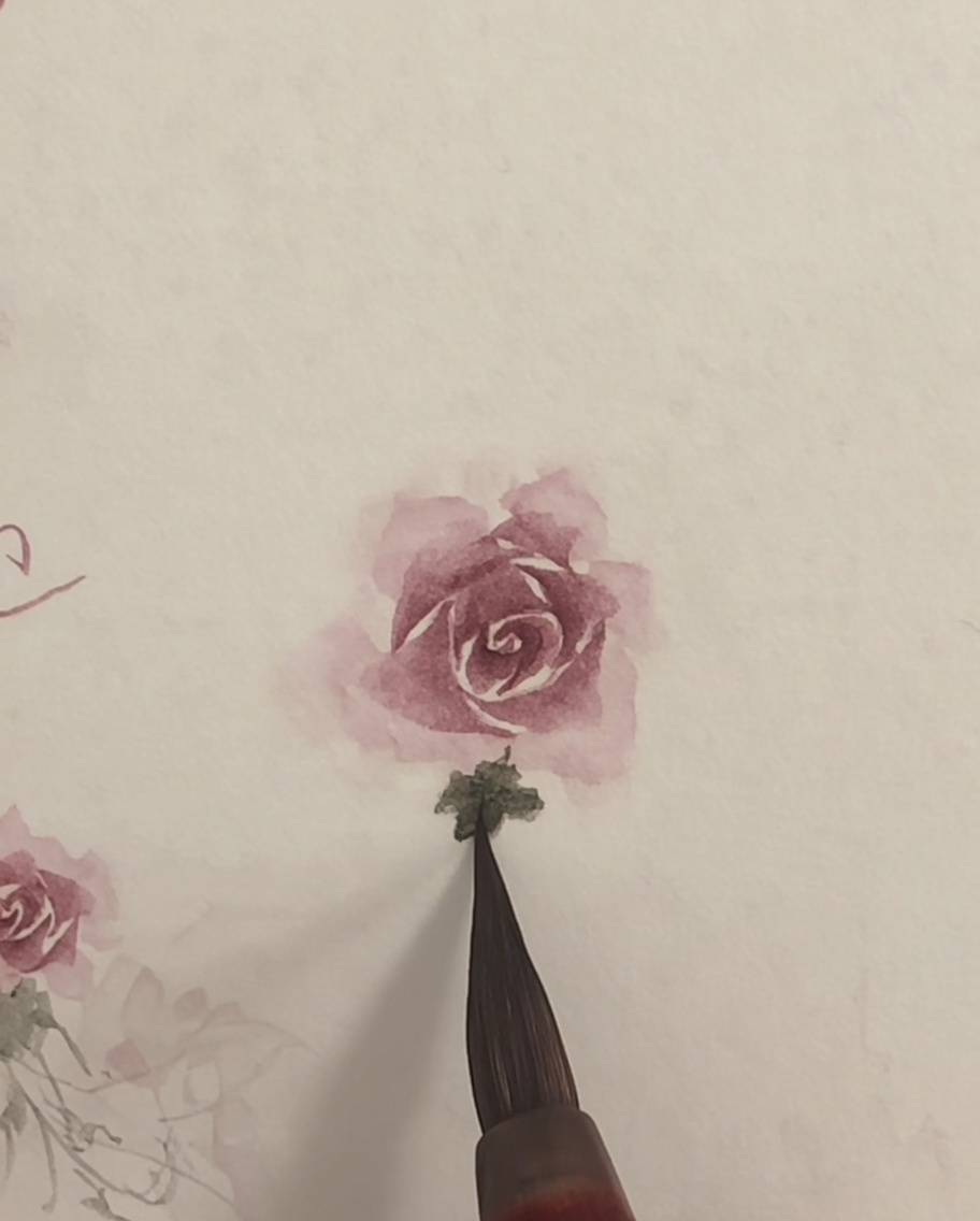 A clean brush lightly blending the edges of a pink watercolor rose on white paper.