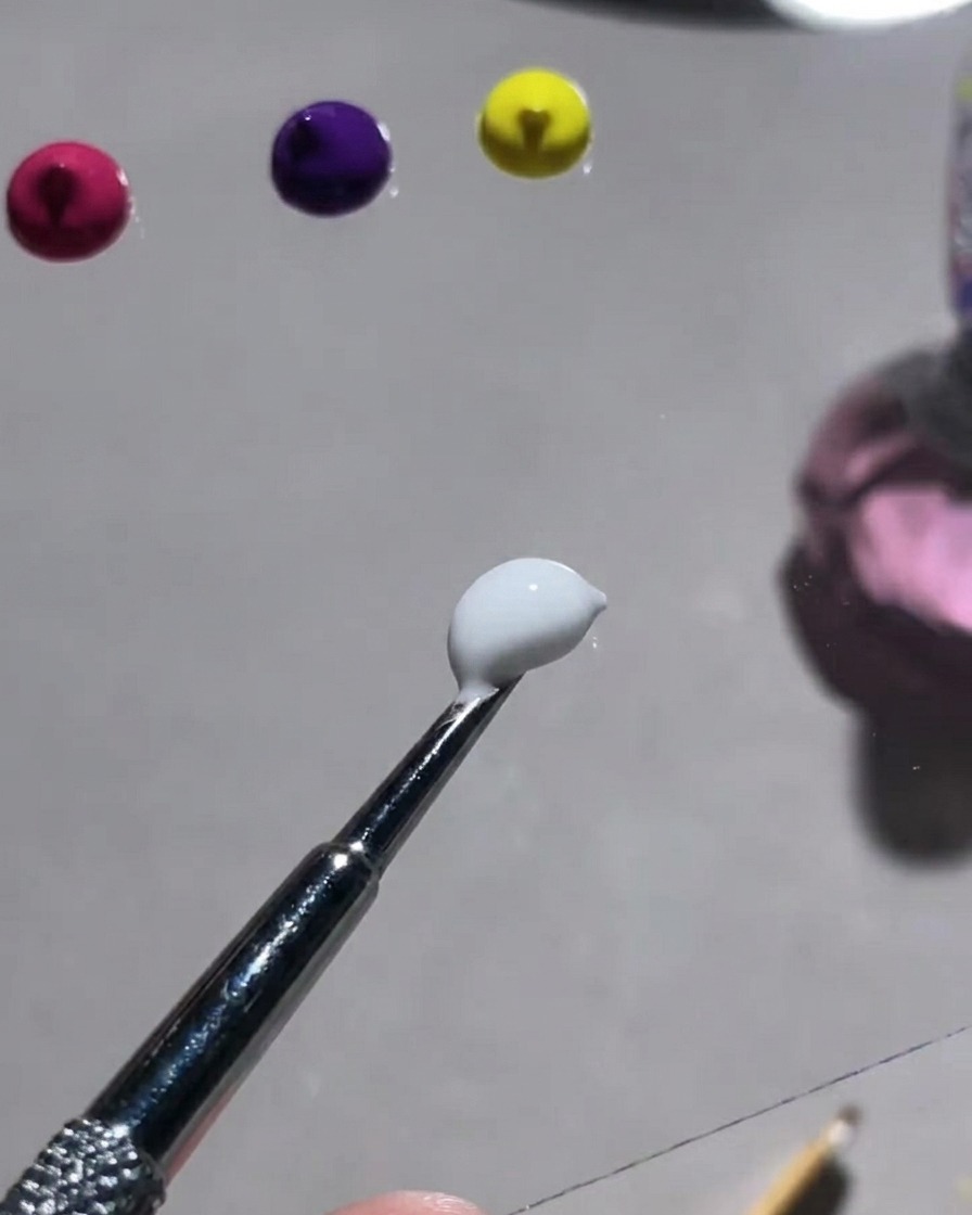 A palette showing various vibrant color powders and a tool used to mix them with white gypsum gel.