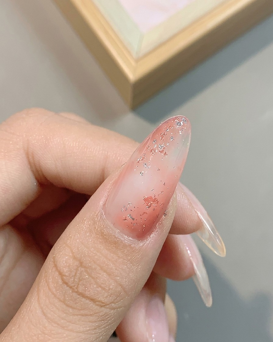 Close-up showing the metallic shimmer of the No. 04 platinum silver gel applied over the glittery pink nail.