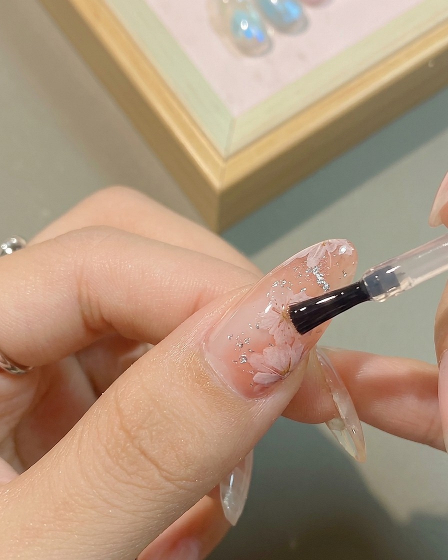A detail shot of a metallic silver gel being applied to the heart of a painted flower.