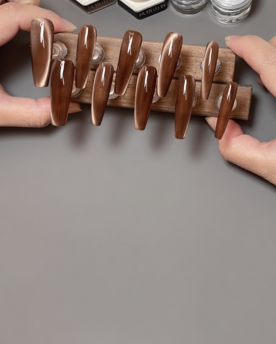 A brush applying a matte top coat over a set of cat-eye nails.