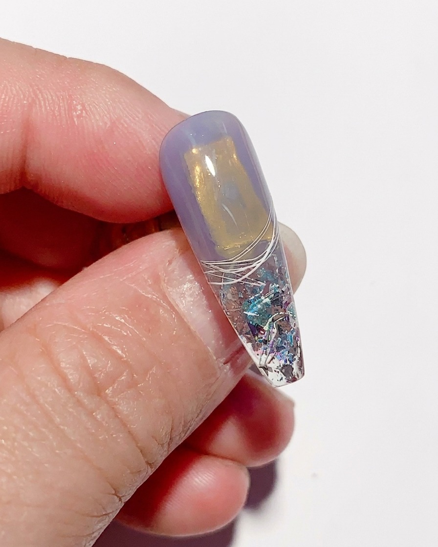 A textured, cured nail tip after the cling film has been peeled away, revealing a unique, crinkled glass finish.