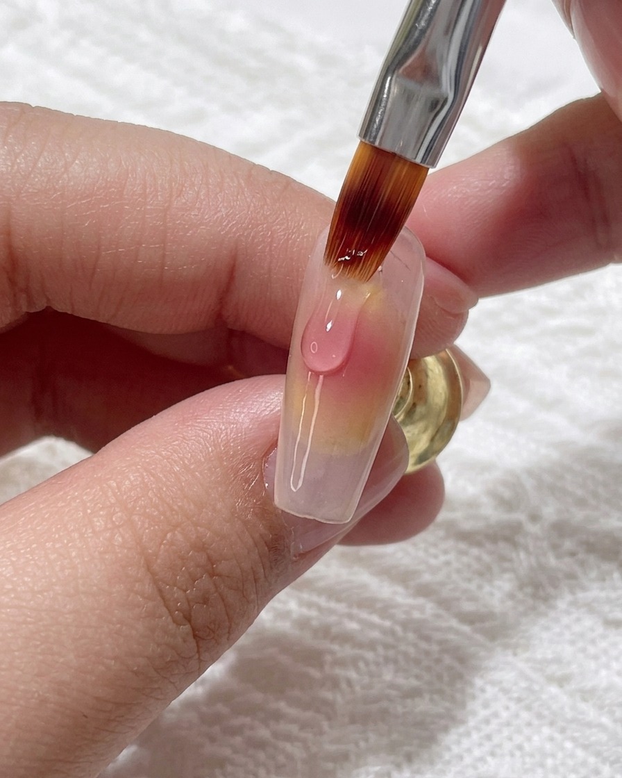 Applying a fresh drop of pink gel onto the existing gradient to deepen the color.