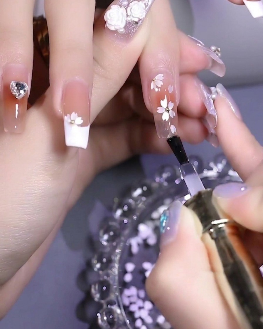 A close-up of a hand inside a UV/LED nail lamp curing the final top coat application.