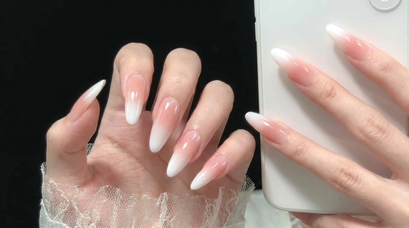 A brush applying a clear base coat onto a clean, prepped nail.