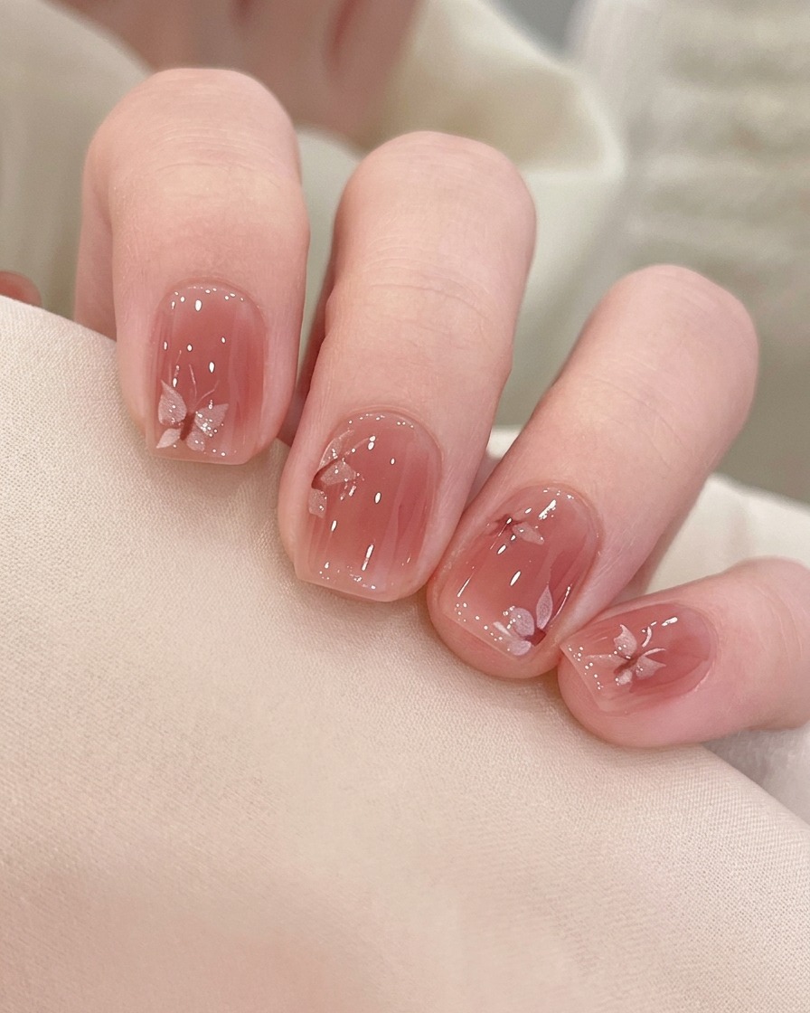 A brush applying a second coat of pink magnetic gel over the existing color.
