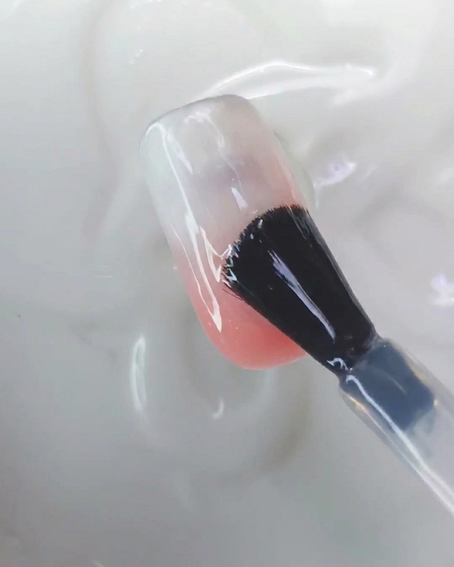 A silicone tool rubbing aurora chrome powder onto the surface of a nail.
