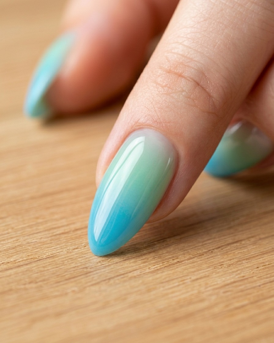 A hand using a wax-tipped rhinestone picker tool to place small decorative stones onto a manicured fingernail.