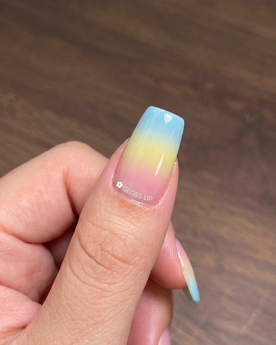 A brush applying a coat of cat-eye gel polish number 25 over the cured colorful gradient base.