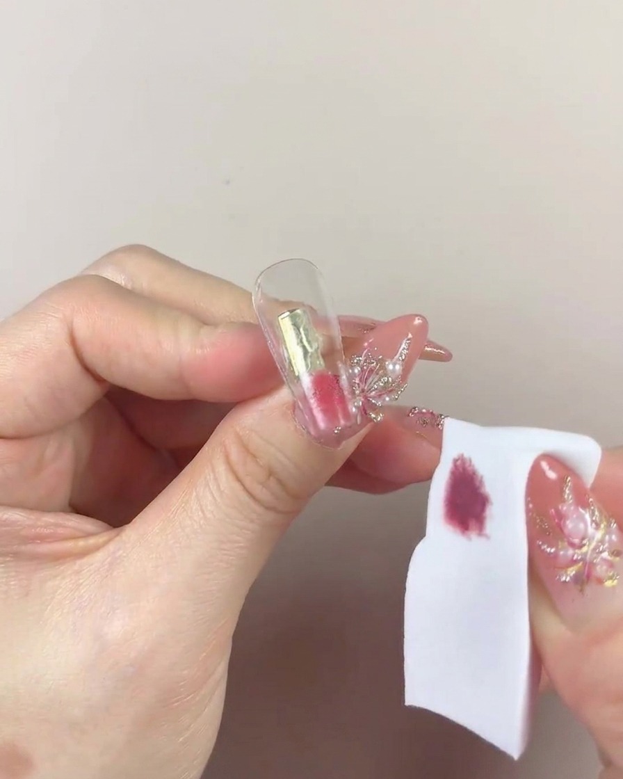 A close-up view showing the sponge patting the gel repeatedly onto the nail tip.