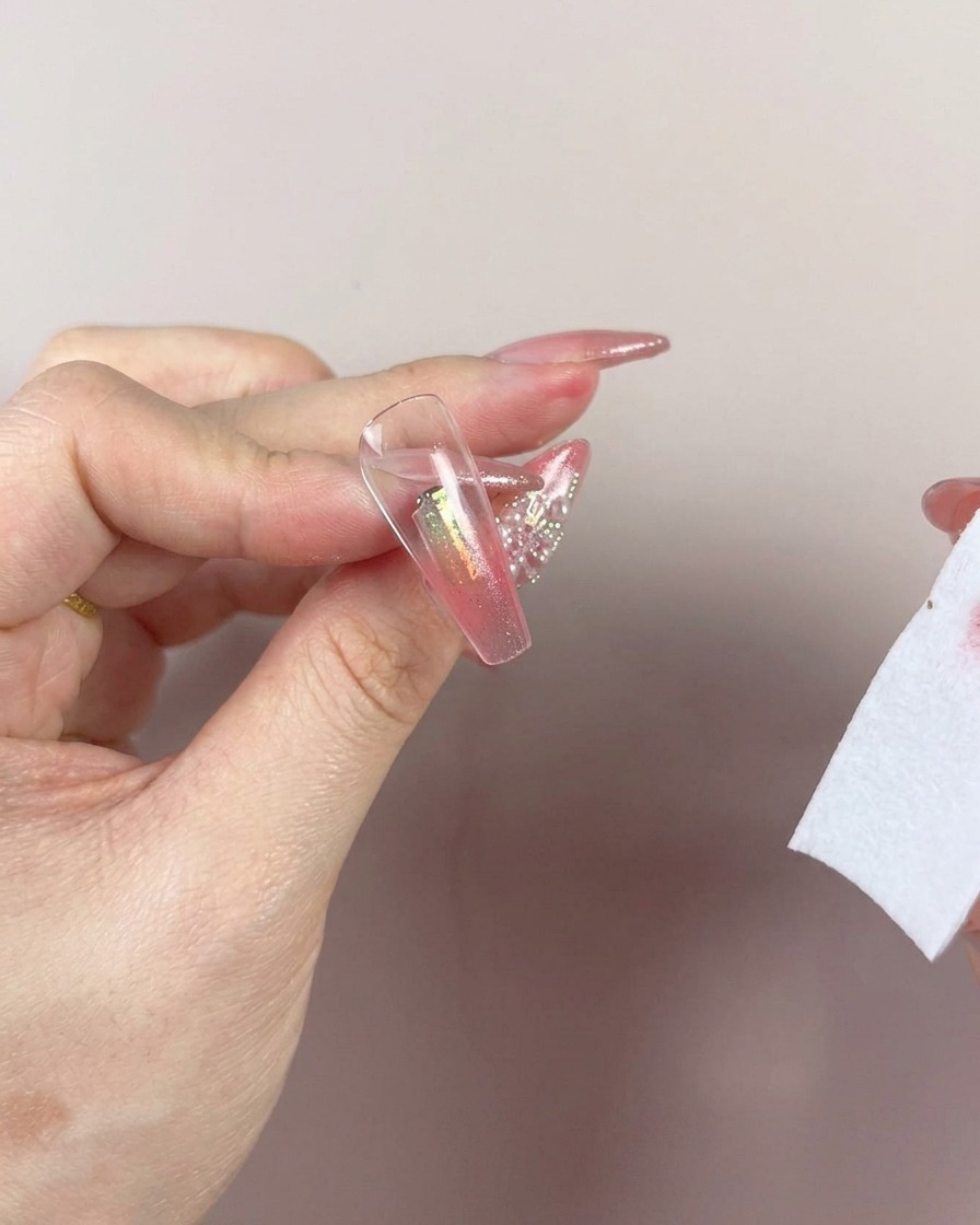 The edge of a makeup sponge blending the color up toward the cuticle area of the nail.