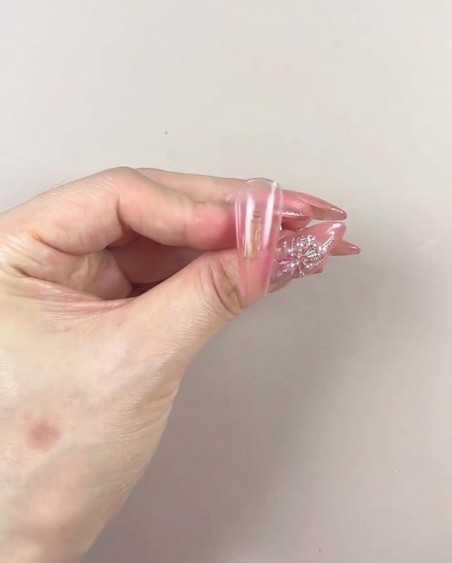 A manicured hand placed inside a UV/LED nail lamp for curing the gel gradient layer.