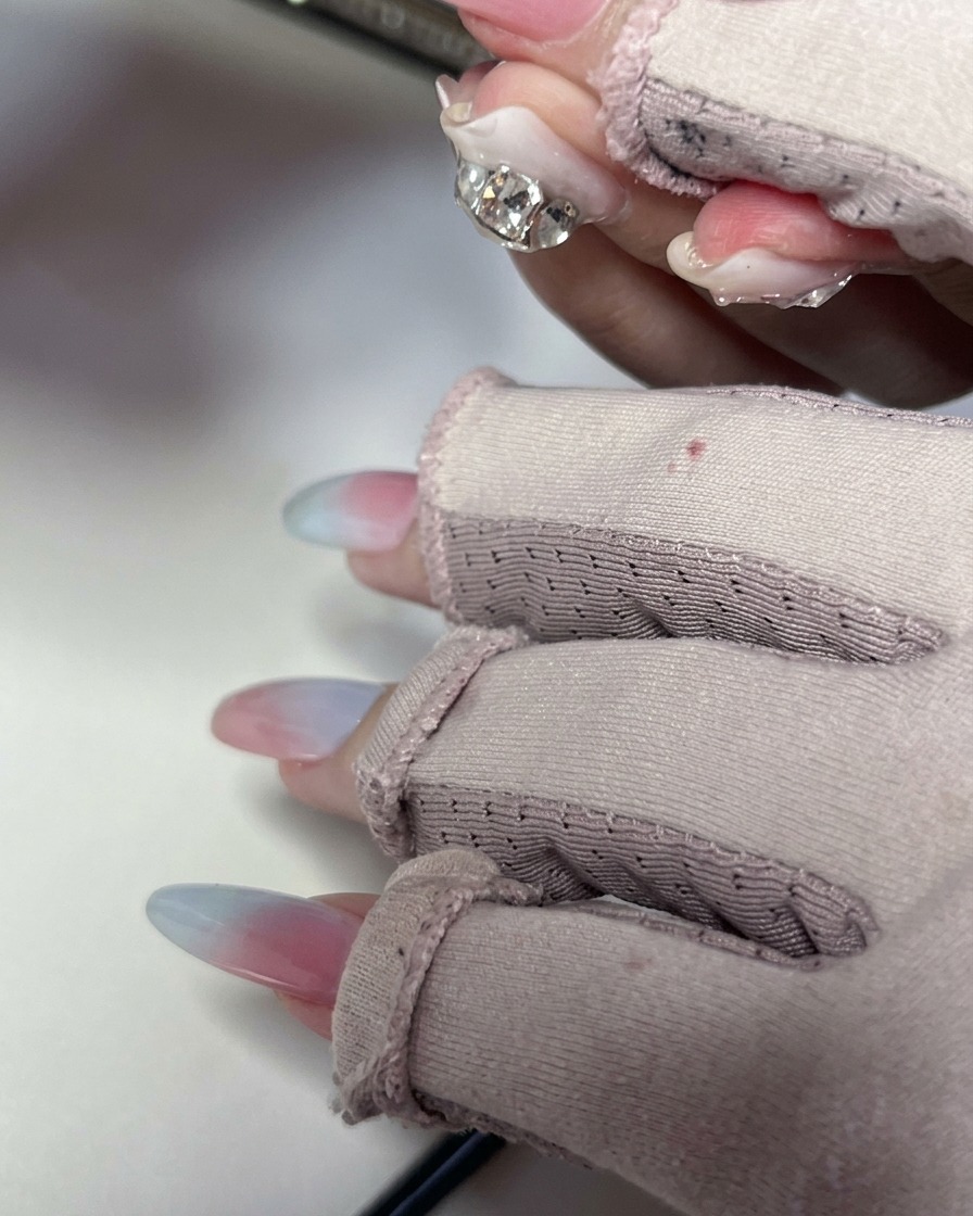 A sponge lightly tapping over the nail surface to smooth out the gel gradient.