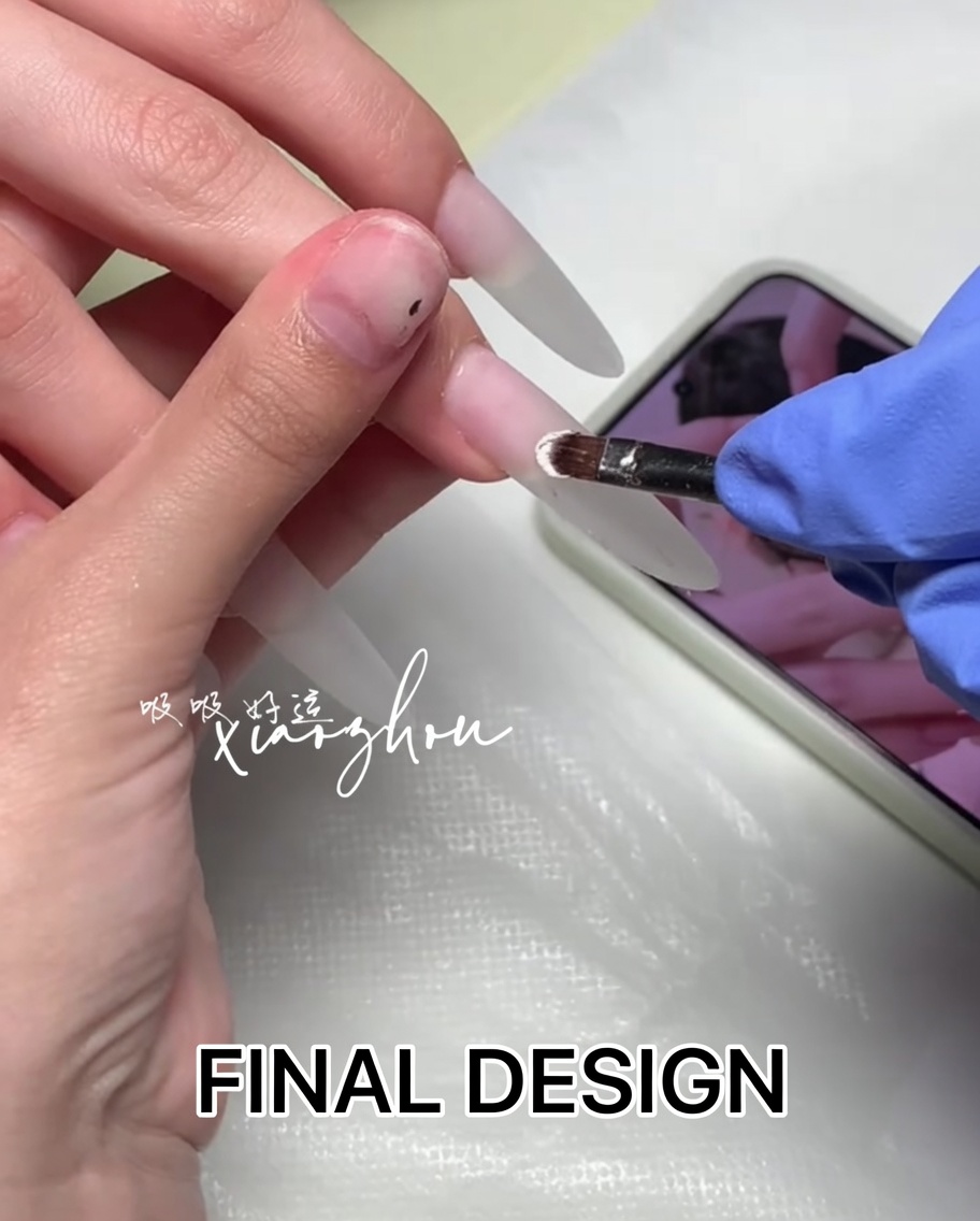 A close-up view of a brush applying a clear base coat to a natural nail.