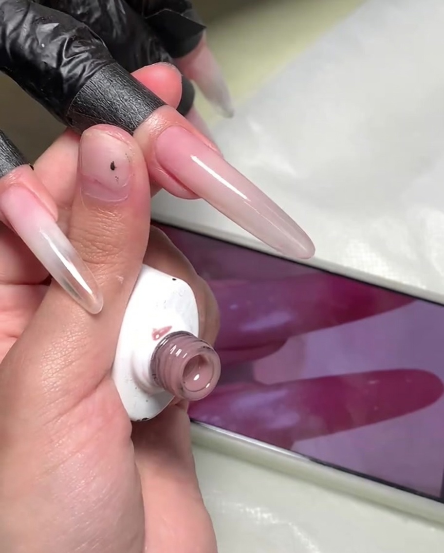A small sponge being used to dab the transition area between the two gel colors.