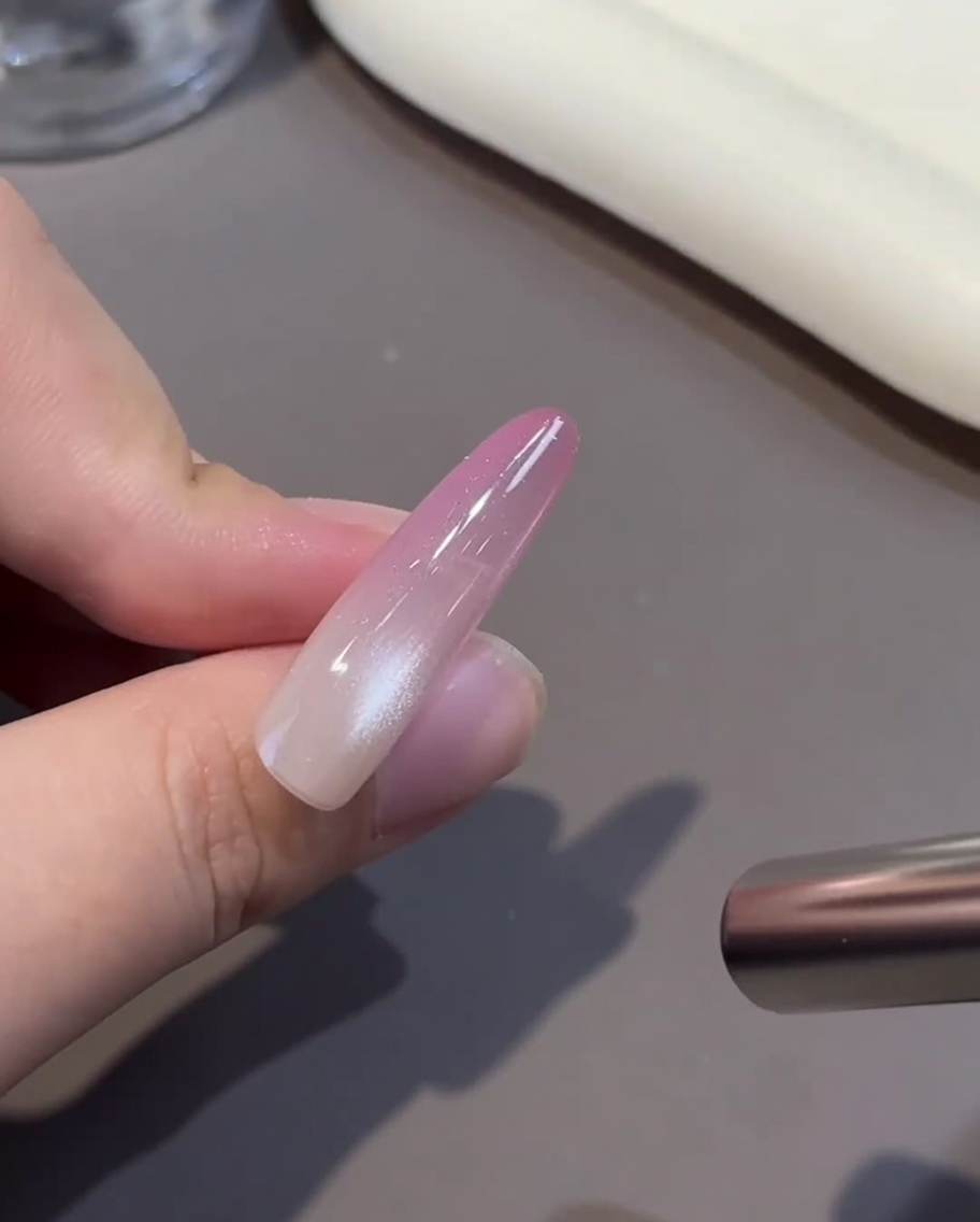 A nail positioned inside a UV/LED lamp for the curing process.