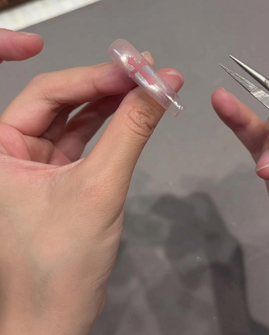 A lint-free wipe being used to clean the surface of a finished cat eye nail.