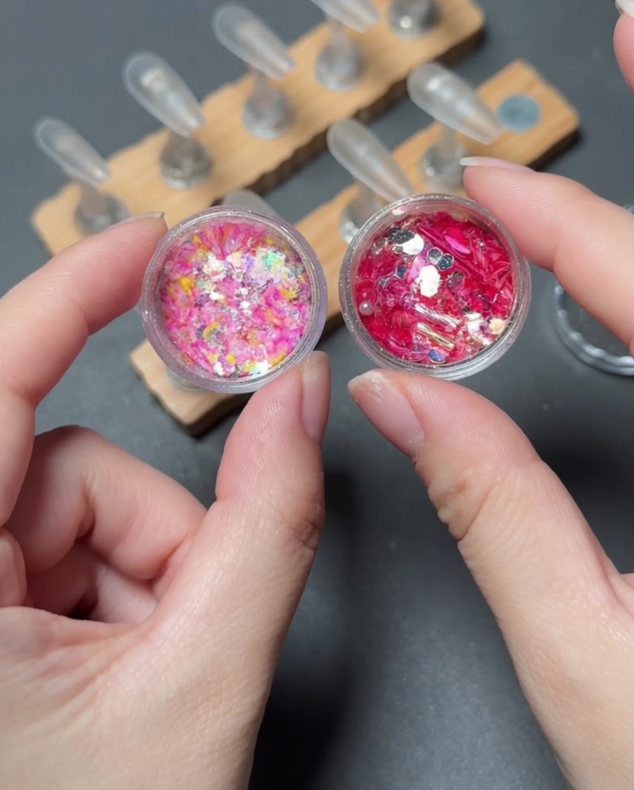 A brush placing vibrant, multi-colored sequins onto the tip area of a press-on nail.
